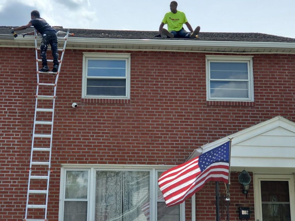 Handi Boyz crew working on a brick home flying an American flag